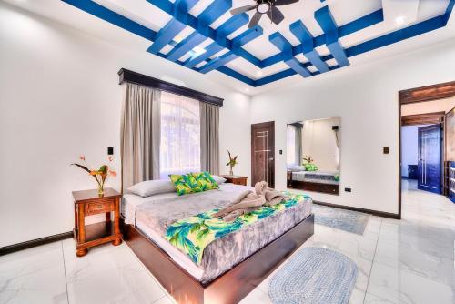 a bedroom with a large bed with a blue ceiling at Samanea House Deluxe, big pool, 10min from PV in Hone Creek