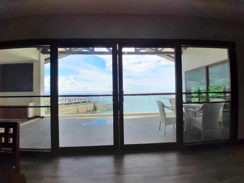 a living room with a view of the ocean at Cuna Mangodlong Paradise Beach Resort in Camotes Islands