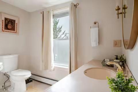 a white bathroom with a toilet and a sink at NEW! Family-Friendly Getaway -1 Mi to Dtwn Salem w Roof Deck & Tiki Bar in Salem