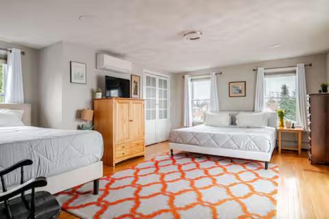 a bedroom with two beds and a rug at NEW! Family-Friendly Getaway -1 Mi to Dtwn Salem w Roof Deck & Tiki Bar in Salem