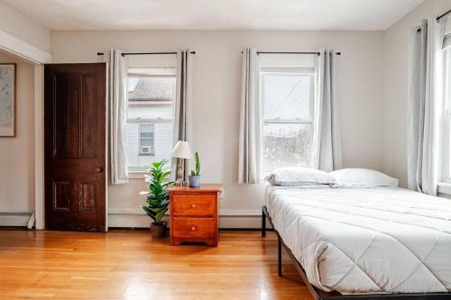 a bedroom with a large bed and two windows at NEW! Family-Friendly Getaway -1 Mi to Dtwn Salem w Roof Deck & Tiki Bar in Salem