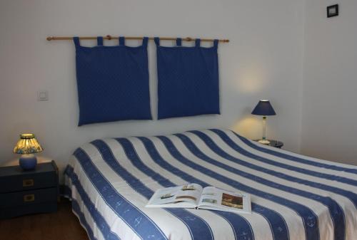 a bedroom with a bed with a book on it at Les Keriaden's in Pleudihen