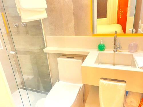 a bathroom with a toilet and a sink and a shower at Petite Suite Juquehy - A 2 quadras do Mar - Pequena mas completa - 13 metros quadrados - Ar cond - Frigobar - Microondas - TV Smart - Serviço de Praia - Roupa cama e banho luxo - Wi Fi - Janelas e portas acústicas - Tudo Novo e cheiroso! in Juquei