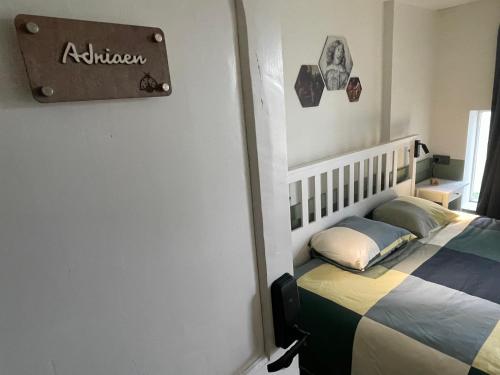 アウデナールデにあるPimpompul Vakantiewoningのベッドルーム1室(壁に看板付)