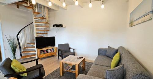 a living room with a couch and a tv at Haushaelfte-Hein-105 in Böhl