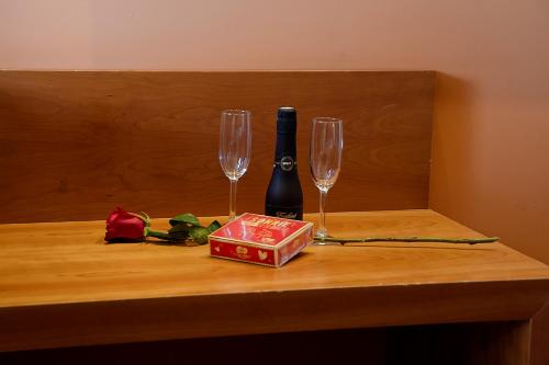 a table with two wine glasses and a box at Hotel AS Torrent in Torrent