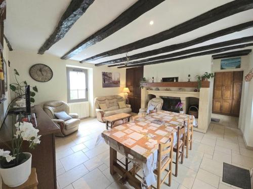 un salon avec une table et une cheminée dans l'établissement Maison en pierres avec jardin et parking près de Sarlat - FR-1-616-478, à Marquay