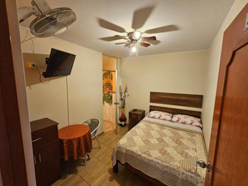 una camera da letto con un letto e un ventilatore a soffitto di Hospedaje Valencia a Ica