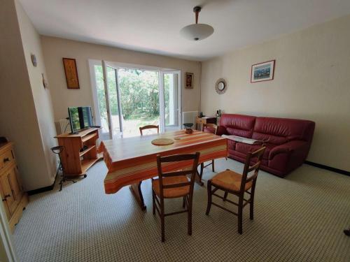 un salon avec une table et un canapé rouge dans l'établissement Villa calme entre bassin et océan, terrasse, 4 pers. - FR-1-736-60, à Lège-Cap-Ferret
