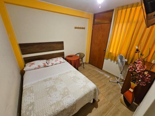 una camera con letto e scrivania con ventilatore di Hospedaje Valencia a Ica