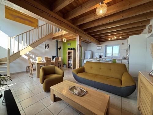 a living room with a couch and a table at Gîte chaleureux avec jardin clos en Auvergne - FR-1-489-573 in Saint-Bonnet-de-Rochefort