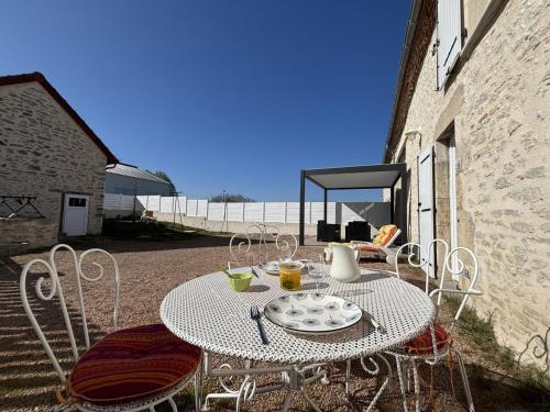 a white table and chairs on a patio at Gîte chaleureux avec jardin clos en Auvergne - FR-1-489-573 in Saint-Bonnet-de-Rochefort