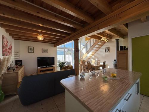 a kitchen and living room with a wooden ceiling at Gîte chaleureux avec jardin clos en Auvergne - FR-1-489-573 in Saint-Bonnet-de-Rochefort