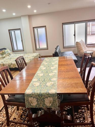 a living room with a wooden table and chairs at 映画館みたいなお部屋で非日常体験 キッチン付きで家族も安心 1日1組限定貸切ステイ シンカイハウス in Izu