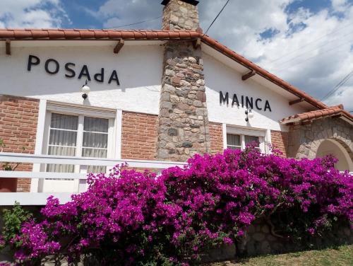 a building with purple flowers in front of it at Posada Mainca in Los Cocos