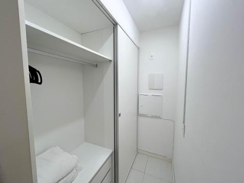 a small white bathroom with a glass shower door at Flat particular no hotel Fusion in Brasilia