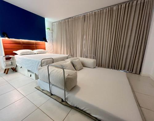 a bedroom with two beds and a large window at Flat particular no hotel Fusion in Brasilia