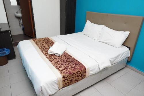 a bed with two towels on top of it at Hotel Shri Putiri in Pasir Gudang