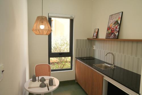 una cucina con lavandino, sedia e finestra di NUBA Homestay and Coffee Buôn Ma Thuột a Buôn Ma Thuột