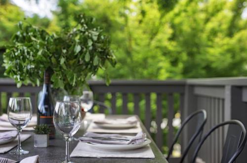 a table with two wine glasses and a potted plant at Gracemont Boutique Accommodation in Healesville