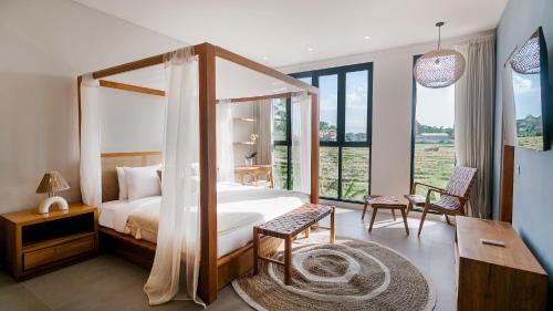 1 dormitorio con cama con dosel y ventana grande en Sunset D1 Villa by Betterplace, en Kerobokan