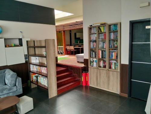 a living room with bookshelves and a staircase with books at Đồi Sao Homestay in Buon Ma Thuot