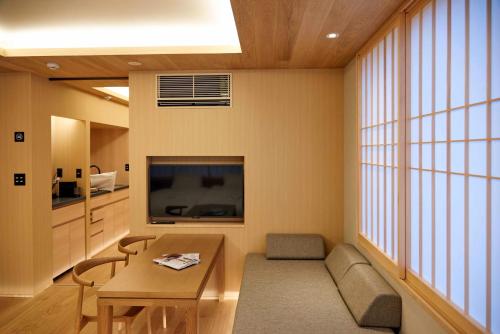 a living room with a table and a large window at MKG HOTEL Asakusa in Tokyo