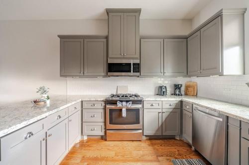 a kitchen with stainless steel appliances and gray cabinets at Private, city view , 5 beds, 2 balconies, Jacuzzi in Houston