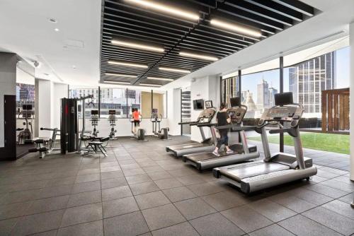 a gym with cardio equipment in a large building at Luxurious 2BR Apartment - Central CBD Location with Pool, Gym in Melbourne