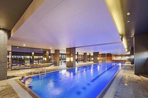 a large swimming pool in a building with people in it at Luxurious 2BR Apartment - Central CBD Location with Pool, Gym in Melbourne