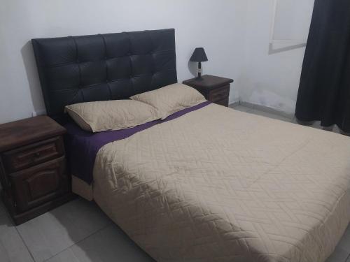 una camera da letto con un letto grande con testiera nera di Mate host 2 a Córdoba