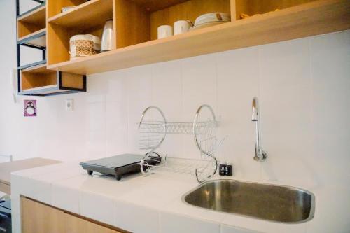 a kitchen counter with a sink and a kitchenventory at Relaxing Designed Studio at Tokyo Riverside PIK 2 Apartment By Travelio in Rawalembang