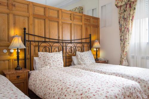1 dormitorio con 2 camas y cabecero de madera en Hostal Adria Santa Ana, en Madrid
