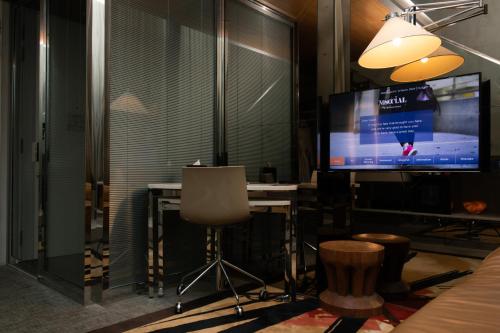 a room with a tv and a table and a chair at M Social Singapore in Singapore