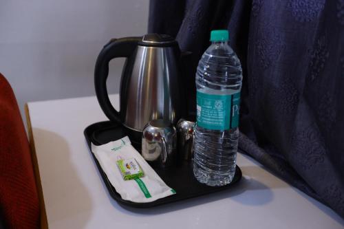 a bottle of water and a tea kettle on a table at Hotel Starlight Chennai near DLF,L&T,Miot,Tradecenter,Ramachandra medical coll in Chennai