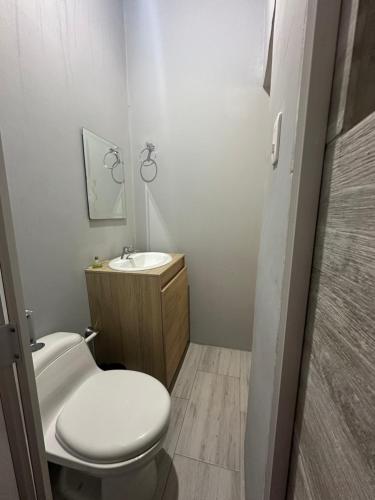 ein kleines Badezimmer mit Toilette und Waschbecken in der Unterkunft Los Atardeceres in Manaure