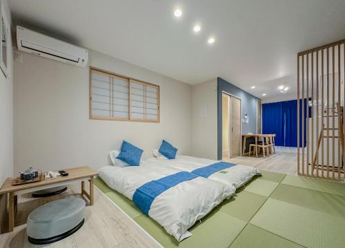 a bedroom with a large bed and a table at 花渓居 绫 in Osaka