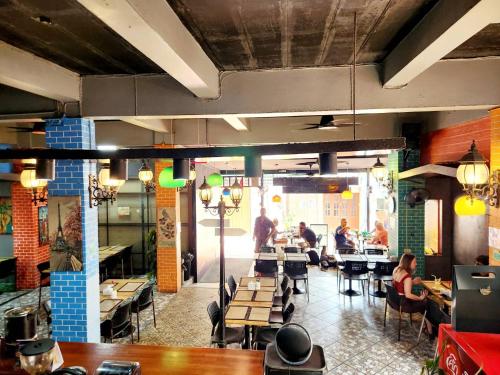 a dining room with people sitting at tables in a restaurant at Casa Picasso Near Chabad House in Bangkok