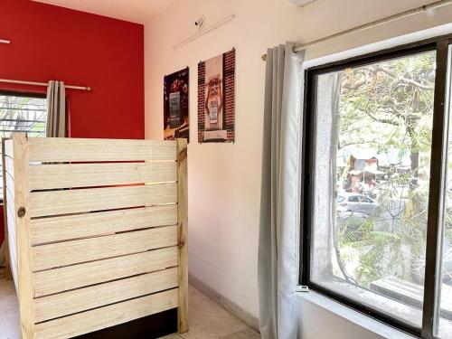 a bedroom with a wooden door and a window at Hostel Lifespace- Tailor made for working professionals- Luxurious Twin Bungalow with CoWork- only 3 and 4 share Rooms in Pune