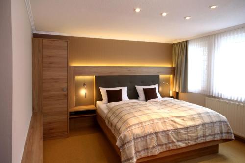 a bedroom with a large bed with a wooden headboard at Landhaus Silberberg in Winterberg