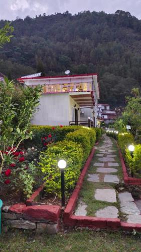 a walkway in front of a building with a mountain at The Pines Mountain View in Rudraprayāg