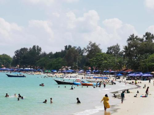 a group of people in the water at a beach at Seri Bulan Coastal Homestay in Kampung Teluk Kemang