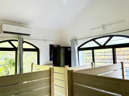 a room with two benches and two windows at Hostel Lifespace- Tailor made for working professionals- Luxurious Twin Bungalow with CoWork- only 3 and 4 share Rooms in Pune