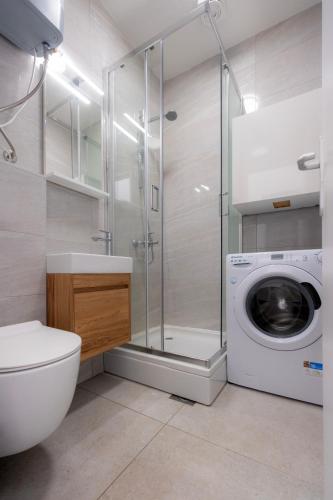a bathroom with a washing machine and a washer at Sunny Apartment Octopus in Prožura