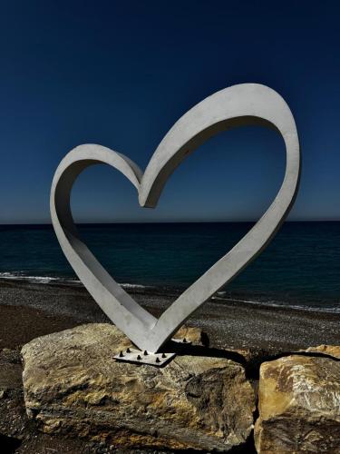 a heart cut out of a rock on the beach at Kissonerga Sea Breeze Apartments Panoramic Ocean View in Kissonerga
