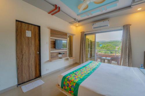 a bedroom with a bed and a window with a view at Treebo The Venna Hill in Mahabaleshwar