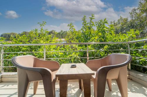 a patio with two chairs and a table on a balcony at Treebo The Venna Hill in Mahabaleshwar