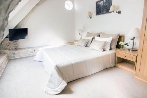 a bedroom with a white bed and a tv at Domus Maria in Vilnius