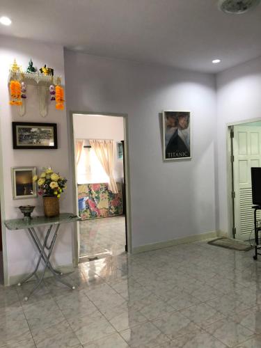 a room with white walls and a table with flowers at PhimHomeStayCR in Ban Thung Ngio