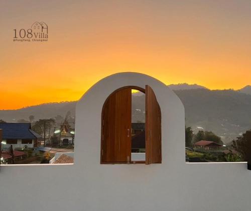 a window in a building with a sunset in the background at 108 Villa @ PongYang in Chiang Mai